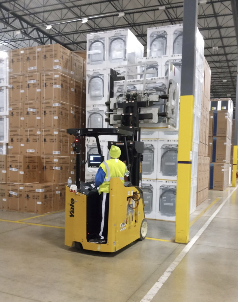 Associate Unloading Packages on Forklift